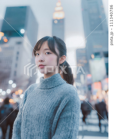ビル街の雑踏で立つニットを着た女性 111340786