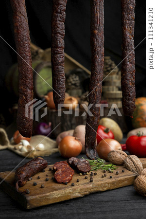 Smoked, aged sausages with fresh vegetables and food ingrediets Smoked, aged sausages with fresh vegetables and food ingrediets 111341210