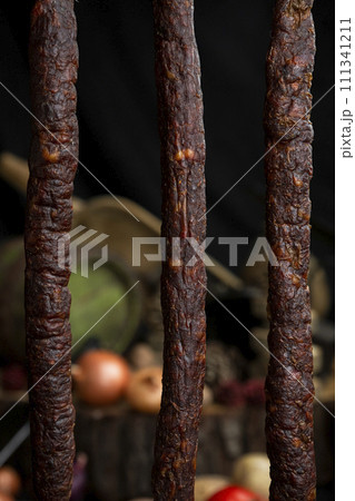 Smoked, aged sausages hanging in the kitchen 111341211