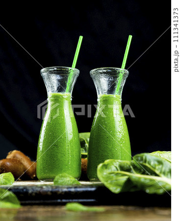 Healthy green smoothies with spinach, apple, kiwi, broccoli and mint in glass jar with fruits and vegetables on the wooden table. Detox and healthy concept 111341373