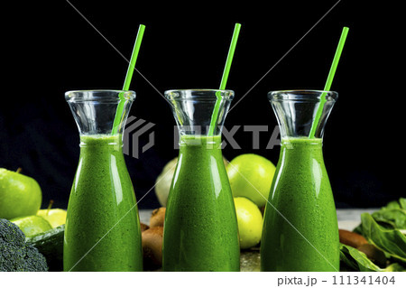 Healthy green smoothies with spinach, apple, kiwi, broccoli and mint in glass jar with fruits and vegetables on the wooden table. Detox and healthy concept 111341404