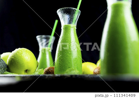 Healthy green smoothies with spinach, apple, kiwi, broccoli and mint in glass jar with fruits and vegetables on the wooden table. Detox and healthy concept 111341409
