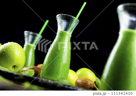 Healthy green smoothies with spinach, apple, kiwi, broccoli and mint in glass jar with fruits and vegetables on the wooden table. Detox and healthy concept 111341410