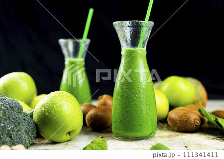 Healthy green smoothies with spinach, apple, kiwi, broccoli and mint in glass jar with fruits and vegetables on the wooden table. Detox and healthy concept 111341411