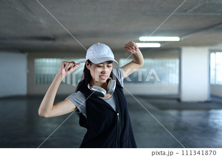 Talented young woman dancing and doing a street freestyle dance in parking garage. Active lifestyle concept 111341870
