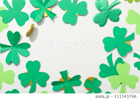 Clover leaves and gold coins on white background, space for text 111343766