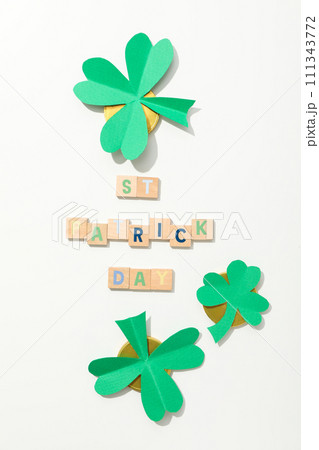 Paper clover leaves, golden coins and letters on white background, top view 111343772