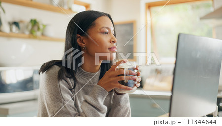 Laptop, coffee and freelance with a woman entrepreneur in the kitchen of her home for small business. Computer, report or email with a young female employee remote working on a startup from her house 111344644