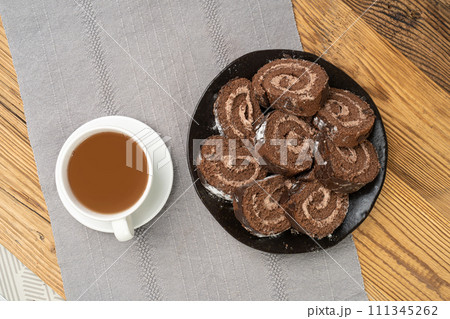 Chocolate Swiss Roll, Round Sponge Cake, Sliced Rolled Vanilla Biscuit with Cocoa Cream Filling 111345262