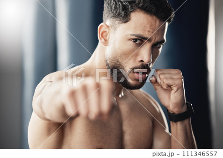Fist, hand and boxing portrait of man, athlete and strong boxer training, exercise and workout in a gym or fitness club. Motivation, health and young fighting professional working on sports endurance Fist, hand and boxing portrait of man, athlete and strong boxer training, exercise and workout in a gym or fitness club. Motivation, health and young fighting professional working on sports endurance 111346557