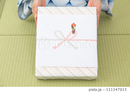 和室の畳に座ってお中元を持つ浴衣を着たミドル女性 和室の畳に座ってお中元を持つ浴衣を着たミドル女性 111347815