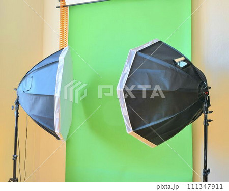 Empty photo studio with lighting equipment. Green background in photo studio Empty photo studio with lighting equipment. Green background in photo studio 111347911