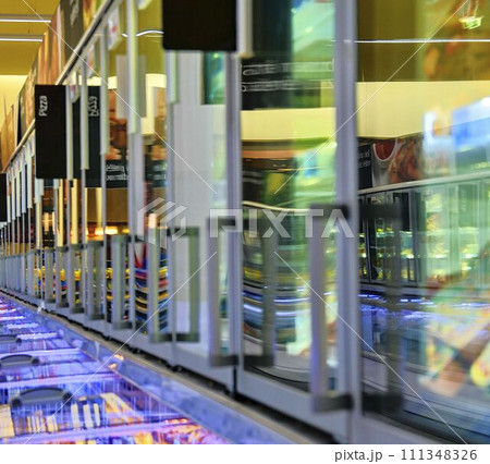 Blurred frozen food section at retail store in Europe. Freezer full assortment of frozen pizza in local supermarket, defocused background Blurred frozen food section at retail store in Europe. Freezer full assortment of frozen pizza in local supermarket, defocused background 111348326