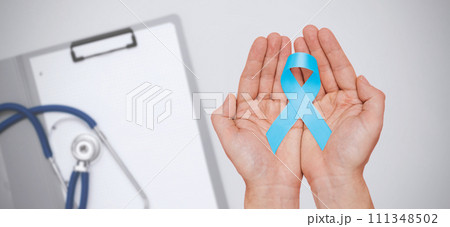Hand holding blue prostate cancer awareness ribbon 111348502