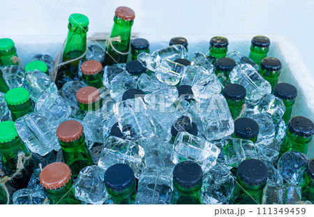 Beer Bottles in Ice Cubes, Many Cold Bottle Caps in Box, Iced Chilled Beer Chest, Different Cold Bottles Beer Bottles in Ice Cubes, Many Cold Bottle Caps in Box, Iced Chilled Beer Chest, Different Cold Bottles 111349459