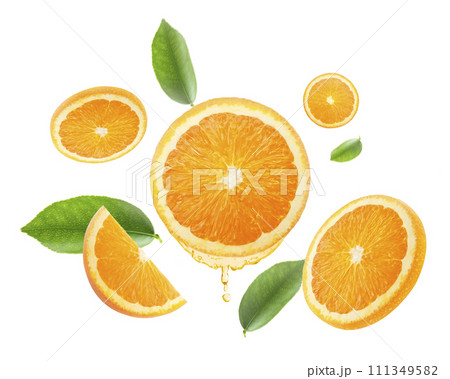 drops of juice from orange half and slices Falling juicy oranges with green leaves flying. defocusing. applicable for advertising 111349582