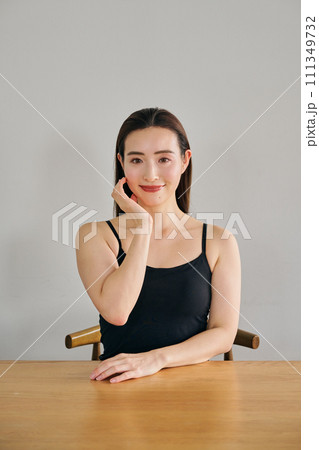 顔をマッサージして肌のお手入れをする30代女性 111349732