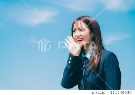 青空をバックに応援をする女子高生 111349936
