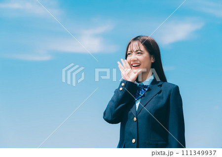 青空をバックに応援をする女子高生 111349937