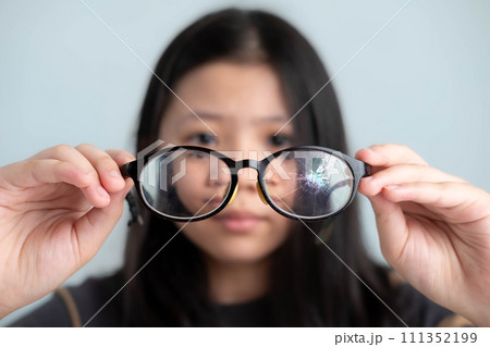 Closeup Broken eyeglasses in the hands of an Asian Caucasian girl, concept of repairing everyday necessities. 111352199