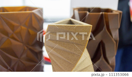 Art object vase printed on 3D printer from melted brown plastic with addition waste coffee. Model made of plastic with spent coffee by 3d printer. Additive progressive technology 3D printing recycling 111353066