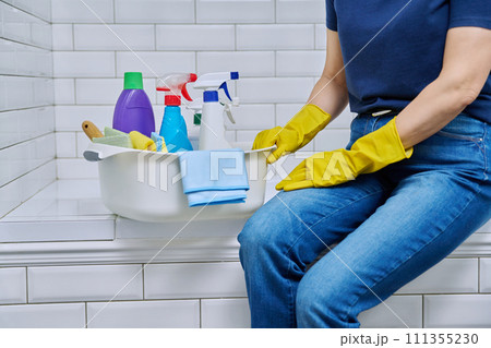 House cleaning concept, basin with cleaning products and hands in gloves House cleaning concept, basin with cleaning products and hands in gloves 111355230