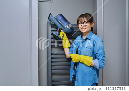 Woman cleaning with a vacuum cleaner in the bathroom Woman cleaning with a vacuum cleaner in the bathroom 111357538