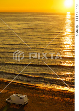 Camper van on beach at sunrise 111358778