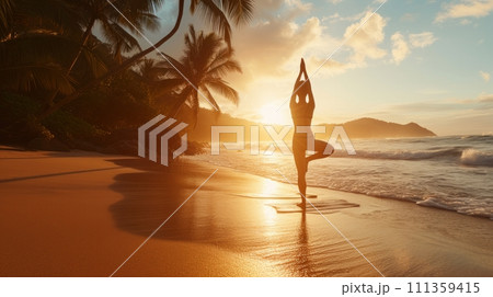 A woman practicing yoga on a serene, secluded beach, her body silhouetted against the sunrise 111359415
