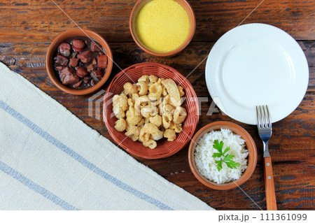 dish and fork next to feijoada, traditional brazilian culinary food top view 111361099