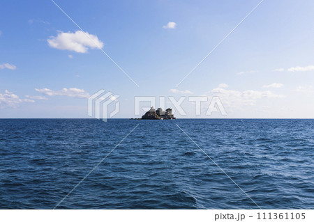 View of  island called Sveta Nedelja (St. Sunday) near Petrovac, Montenegro and blue sky with white fluffy clouds in background 111361105