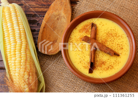 Curau, cream of corn sweet and dessert typical of the Brazilian cuisine, with cinnamon placed in ceramic bowl on wooden table. Top view 111361255