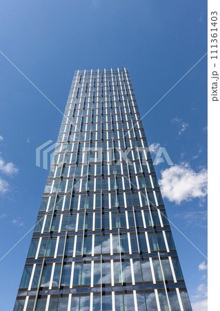 Skyscraper in business district against blue sky. Modern corporate building and architecture Skyscraper in business district against blue sky. Modern corporate building and architecture 111361403