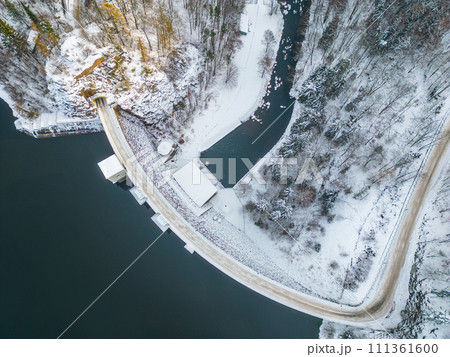 Sec water reservoir with concrete dam and wintertime snowy hills of Iron Mountains around. Czechia. Aerial view from drone. 111361600