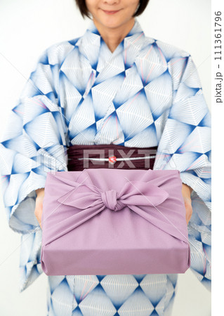 お中元の風呂敷包みを持つ浴衣を着たミドル女性 お中元の風呂敷包みを持つ浴衣を着たミドル女性 111361796
