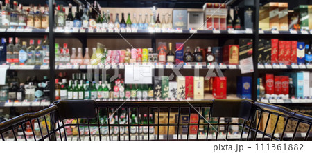 Abstract blurred image of alcohol store with trolley in department store. (Selective focused at shopping cart)	 111361882