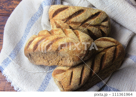 Australian bread loaf on fabric over rustic wooden background. Traditionally this bread is made with chocolate powder, brown sugar and honey Australian bread loaf on fabric over rustic wooden background. Traditionally this bread is made with chocolate powder, brown sugar and honey 111361964