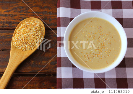 Tahini in ceramic bowl on rustic wooden table- cream or paste made from sesame seeds (sesame) widely used in Middle Eastern cuisine Tahini in ceramic bowl on rustic wooden table- cream or paste made from sesame seeds (sesame) widely used in Middle Eastern cuisine 111362319
