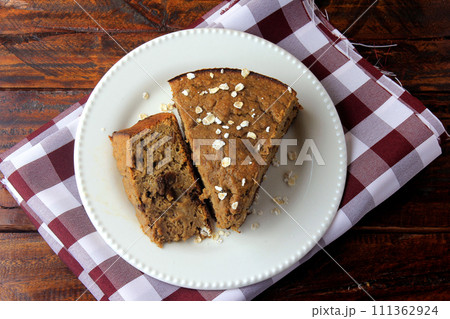 Healthy homemade banana cake made with oatmeal on rustic wooden table. sugar-free, milk-free, gluten-free Healthy homemade banana cake made with oatmeal on rustic wooden table. sugar-free, milk-free, gluten-free 111362924