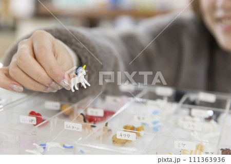 ワークショップをするのにミニチュアの動物を選ぶ女性　 111363936