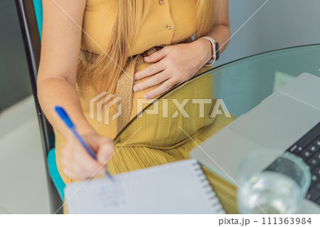 Beautiful pregnant woman working on laptop. Young businesswoman working in her office 111363984