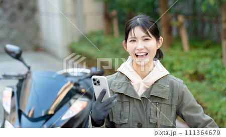 スマホを持つバイク女子 111364679
