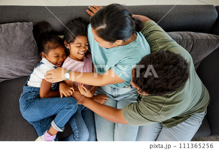 Comic family, happy sofa and parents with love for children on living room couch, tickling for comedy and smile together in lounge. Girl kids laughing while playing with mother and father from above Comic family, happy sofa and parents with love for children on living room couch, tickling for comedy and smile together in lounge. Girl kids laughing while playing with mother and father from above 111365256
