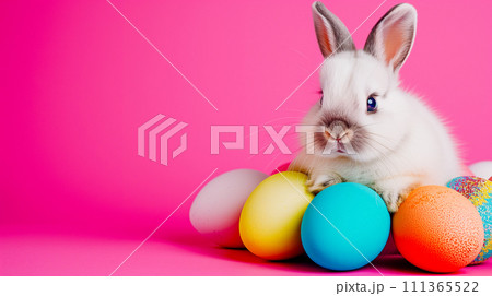 イースターのお祝い。お祝いの模様が描かれた色とりどりの卵に囲まれたふわふわ可愛いうさぎ。 111365522