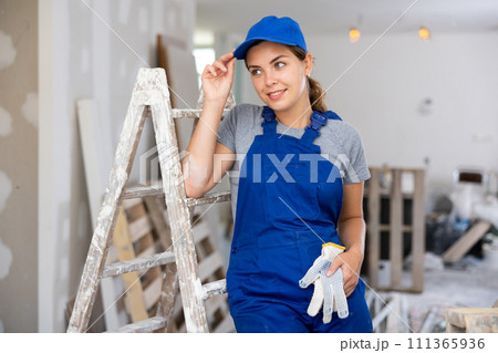 Portrait of positive woman builder during repair works 111365936