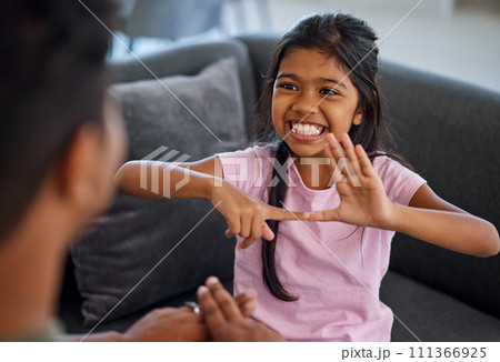 Child, sign language and learning to communicate with deaf girl or parent while making fingers and showing visual symbols at home. Happy kid with hearing disability or loss sitting with a tutor Child, sign language and learning to communicate with deaf girl or parent while making fingers and showing visual symbols at home. Happy kid with hearing disability or loss sitting with a tutor 111366925