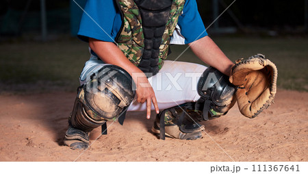 Baseball, player and sign of a sports hand gesture or signals for game strategy showing curveball on a pitch. Catcher holding ball glove in sport secret for team communication during match at night Baseball, player and sign of a sports hand gesture or signals for game strategy showing curveball on a pitch. Catcher holding ball glove in sport secret for team communication during match at night 111367641