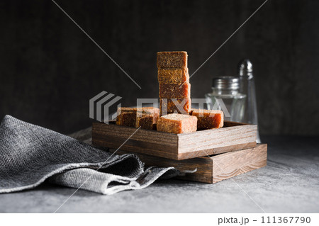 Brown sugar in wooden box on slate background Brown sugar in wooden box on slate background 111367790
