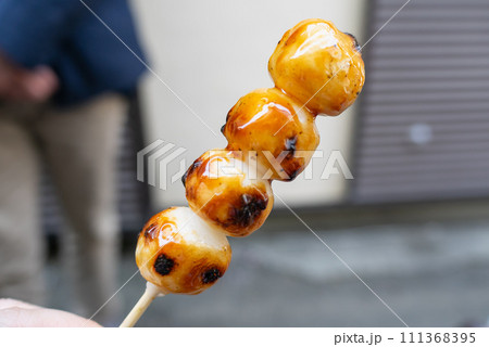 串にささった甘辛い醤油味のみたらし団子。 串にささった甘辛い醤油味のみたらし団子。 111368395