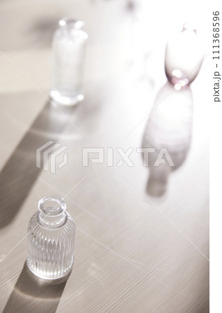 Natural texture of various glass cups on a table with sunlight streaming in. 111368596